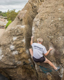 Man wearing a white 100% cotton t-shirt while climbing outdoors